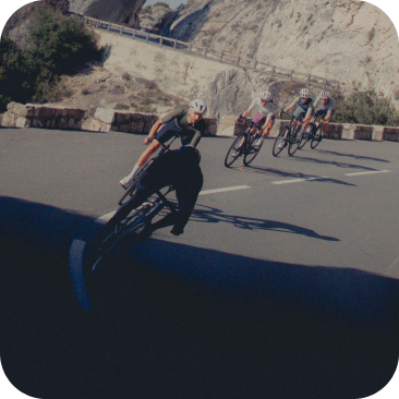 Cyclist aggressively leaning the bike into a tight corner, demonstrating the high clearance angle of the pedals